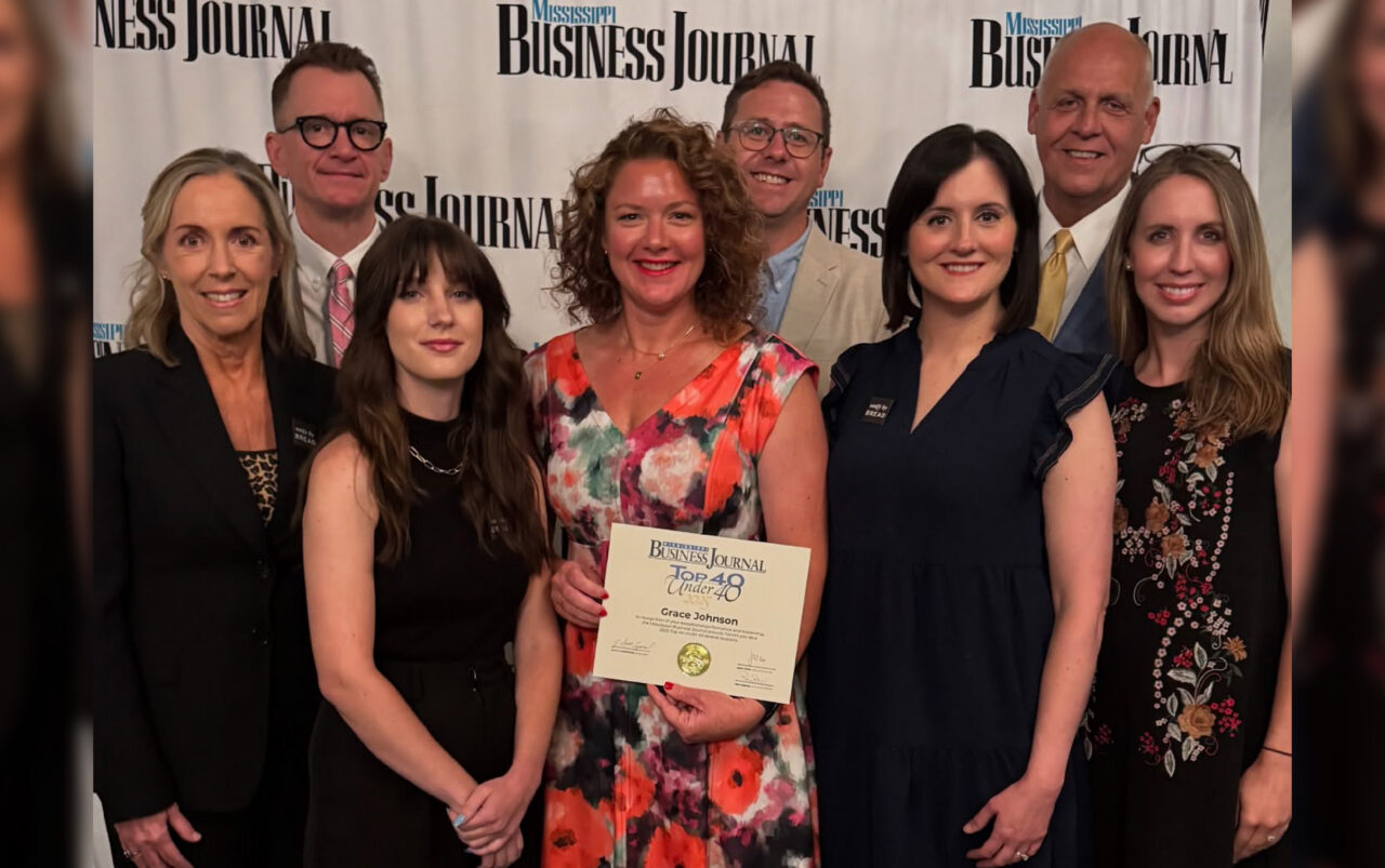 Grace Johnson and her team pose with her award for MS Business Journal's "Top 40 Under 40"